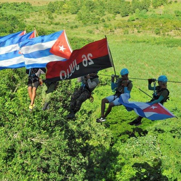 several people on zip line carrying Cuban flags