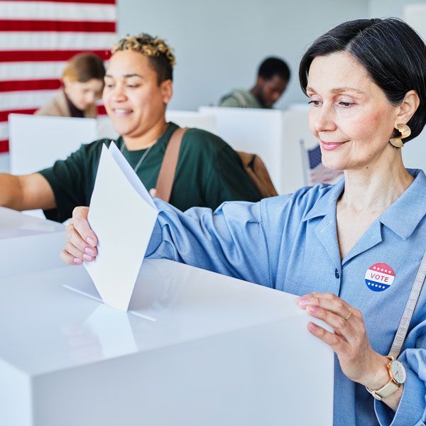 women placing ballots in a ballot box